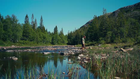 Hombre-Cruzando-Un-Río-En-Indre-Fosen,-Noruega-(foto-Panorámica)