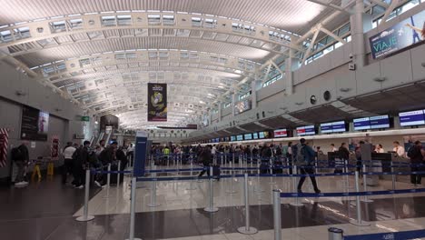 Crowded-check-in-terminal-of-the-Juan-Santamaría-International-Airport-where-the-travelers-queue-for-luggage-drop-at-the-airlines'-desks-in-San-Jose,-Costa-Rica