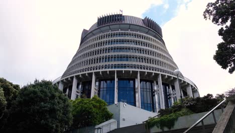 Exterior-view-of-parliament-New-Zealand-Beehive-building-with-flag-in-capital-city-of-Wellington-NZ-Aotearoa