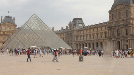 Blick-Auf-Die-Menschenmenge-Im-Innenhof-Des-Louvre-Museums-Mit-Glaspyramide-In-Paris,-Frankreich