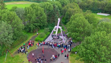 Toma-Aérea-De-Un-Dron-De-Atracciones-En-Un-Parque-Temático-Con-Gente-Disfrutando-De-Los-Juegos-Y-Un-Paisaje-Natural-Ubicado-En-Una-Zona-Residencial