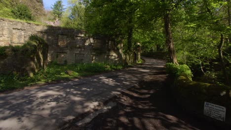 Wide-shot-of-the-lower-bleaching-mill-looking-up-the-road-at-Lumsdale-waterfalls,-Matlock