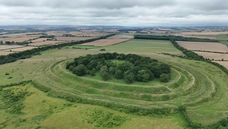 Vista-Aérea-De-Los-Anillos-De-Badbury-En-Dorset,-Un-Histórico-Fuerte-De-La-Edad-De-Hierro,-Crestas-Romanas-Y-Campiña