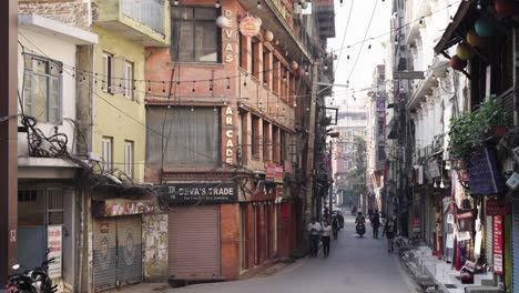 Nepal-Street-Scene-at-sunrise-with-motorbikes,-traffic-and-walking-people