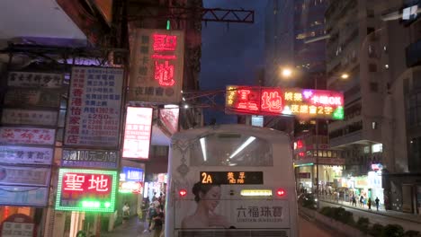 Blick-Von-Der-Erhöhten-Position-Eines-Busses-Auf-Eine-Nächtliche-Verkehrsszene-Im-Stadtteil-Mong-Kok-In-Hongkong-Mit-Zahlreichen-Doppeldeckerbussen-Und-Allgemeinem-Verkehr