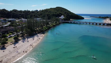 Tourists-Stand-up-Paddle-Boarding-Near-Kevin-Gates-Park-In-Awoonga-Ave,-Burleigh-Heads-QLD,-Australia