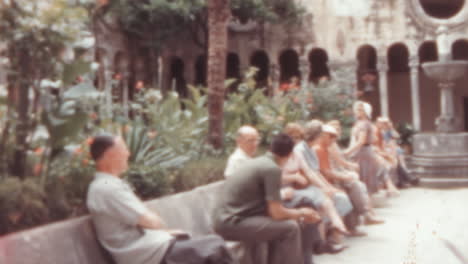 Monjes-Y-Turistas-Sentados-En-Bancos-En-El-Claustro-Franciscano-De-Dubrovnik,-Década-De-1960