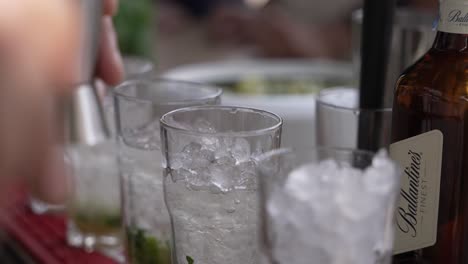 Bartender-pouring-a-drink-over-ice,-preparing-a-cocktail-with-precision-and-care