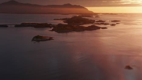 A-picturesque-landscape-of-a-coastal-archipelago-and-the-Atlantic-road-at-sunset,-highlighting-the-tranquil-waters-and-warm-hues