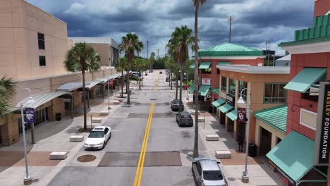 Palm-lined-street-within-the-University-of-Central-Florida-campus,-featuring-shops-and-academic-buildings