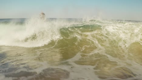 Aerial-follow-in-front-of-big-wave-breaking-and-boogieboarder-flip