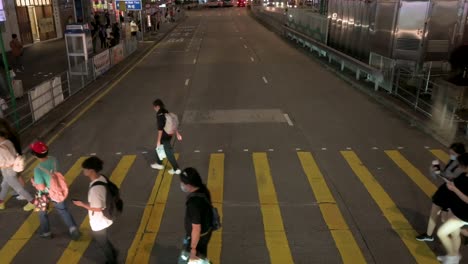 Draufsicht-Auf-Fußgänger,-Die-Nachts-über-Einen-Zebrastreifen-Im-Mong-Kok-Viertel-Von-Hongkong-Gehen