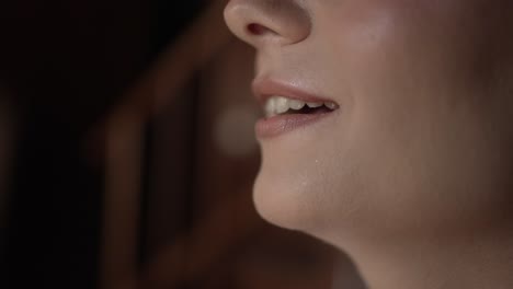 Close-up-of-a-bride's-lips,-softly-smiling-during-makeup-application,-capturing-a-moment-of-quiet-joy