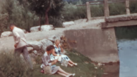 Dos-Mujeres-Relajándose-Junto-Al-Río-Durante-Las-Vacaciones-De-Verano-En-Un-Largo-Viaje-En-Autobús,-Década-De-1960