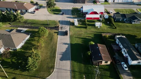 Drone-Captures-Black-Truck-Driving-Through-Canadian-Small-Town-Main-Street