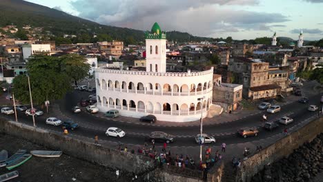 Aerial-view-of-the-Badjanani-Mosque-located-at-Moroni,-Comoros,-surrounded-by-the-cityscape-and-vibrant-street-life-at-sunset