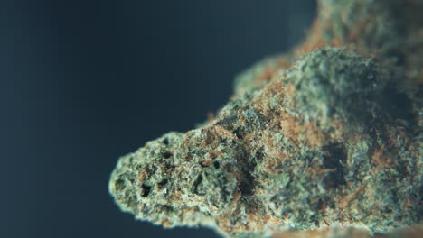 A-vertical-macro-crispy-shot-of-a-cannabis-plant,-hybrid-orange-strains,-green-leaf-Indica-,marijuana-flower,-on-a-360-rotating-stand,-weed-4k