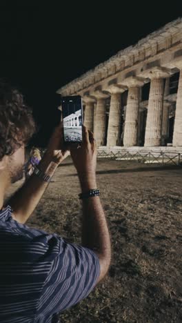 Vertical-video-of-a-tourist-man-photographing-the-ruins-of-the-Greek-temples-of-Paestum