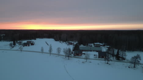 Sonnenuntergang-In-Einem-Kleinen-Verlassenen-Dorf-Im-Norden-Skandinaviens-Im-Winter,-Luftaufnahme