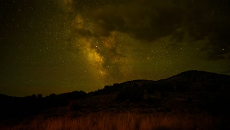 Desde-El-Crepúsculo-Hasta-El-Anochecer,-Cuando-El-Brillante-Núcleo-De-La-Vía-Láctea-Cruza-El-Pico-De-Una-Montaña-Y-El-Resplandor-Verde-Del-Aire-Llena-El-Cielo-Estrellado---Lapso-De-Tiempo