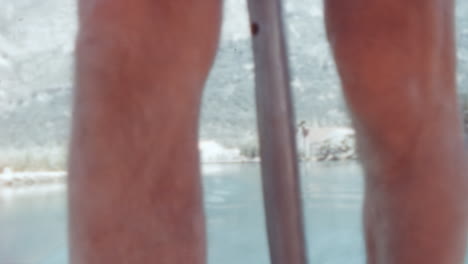 Close-Up-of-Man-Legs-on-Boat-with-Dalmatian-Coastline-in-Background-Dubrovnik