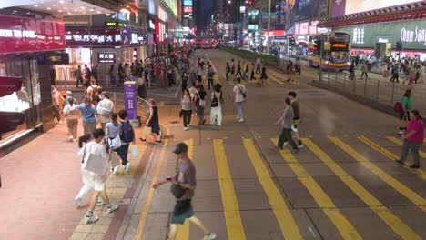 High-viewpoint-of-pedestrians-walking-across-multiple-zebra-crossings-in-the-Mong-Kok-busy-district-of-Hong-Kong-at-night