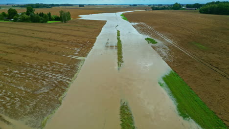 Flooded-road-in-Latvia-countryside,-aerial-dolly-in,-destroyed-infrastructure