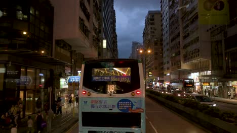 From-an-elevated-view,-a-nighttime-traffic-scene-in-Hong-Kong's-Mong-Kok-area-features-taxis-and-public-buses-amidst-the-bustling-streets-of-Kowloon,-Hong-Kong