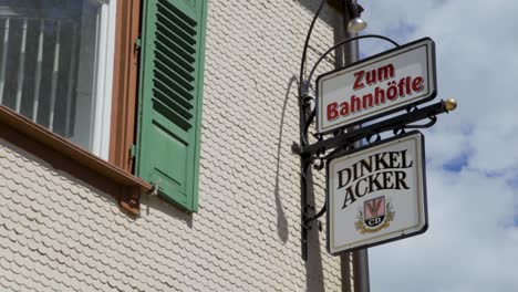 Close-up-of-German-pub-signs-on-a-historic-building-on-a-sunny-day