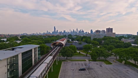 AERIAL:-Train-arriving-at-the-Illinois-Institute-of-Technology,-sunrise-in-Chicago