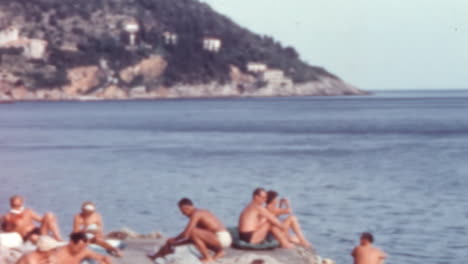 Personas-En-Traje-De-Baño-De-Los-Años-60-Relajándose-En-Una-Terraza-Junto-Al-Mar,-Costa-Dálmata-De-Dubrovnik