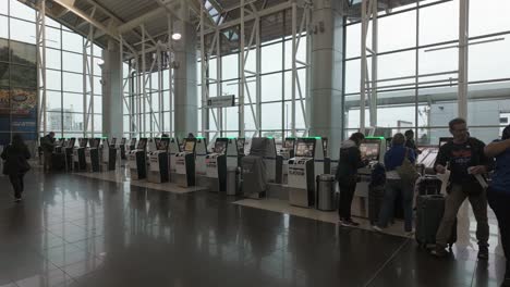 Passagiere-Nutzen-Die-Self-Check-in-Automaten,-Um-Ihre-Flugtickets-Vor-Dem-Abflug-Am-Internationalen-Flughafen-Juan-Santamaria,-San-Jose,-Costa-Rica-Auszudrucken