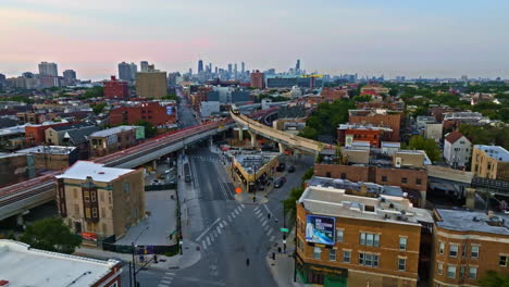 Aerial-view-of-a-train-on-elevated-rails-in-Wrigleyville,-sunrise-in-Chicago,-USA