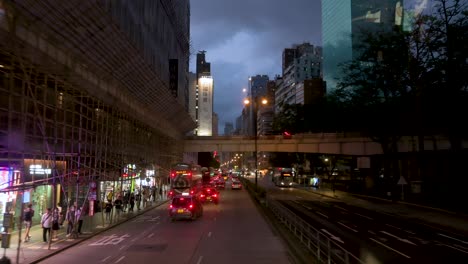 From-an-elevated-perspective,-a-nighttime-traffic-scene-in-Mong-Kok,-Kowloon-showcases-taxis-and-public-buses-amid-the-lively-streets-of-Hong-Kong