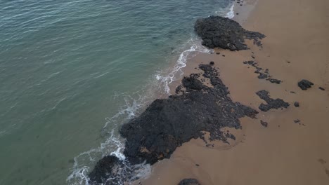 Aerial-seascape-of-Indian-Ocean-waves-crashing-in-to-tropical-beach-in-Mohéli-or-Mwali,-part-of-the-Union-of-the-Comoros