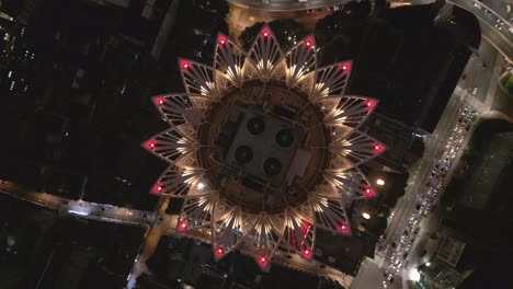 Drone-Tops-Down-Shanghai-Iconic-Architectural-Bund-Center,-illuminated-night-traffic,-Chinese-modern-streets