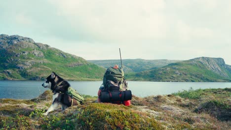 Un-Hombre-Y-Su-Perro-Descansan-En-La-Orilla-De-Pålvatnet-En-Osen,-Condado-De-Trøndelag,-Noruega---Toma-Estática