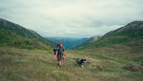 A-Man-and-His-Dog-Hiking-Through-the-Rugged-Hills-of-Osen-in-Trøndelag-County,-Norway---Static-Shot