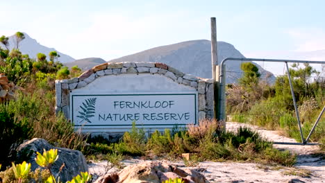 Fernkloof-Nature-Reserve-signage-on-rock-wall-next-to-gate-on-mountain-trail