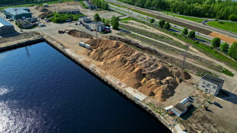 A-Scene-Showing-a-Sand-Pile-in-a-Port-Area-Near-a-Harbor,-With-Equipment-and-Vehicles-Visible-Nearby---Aerial-Drone-Shot