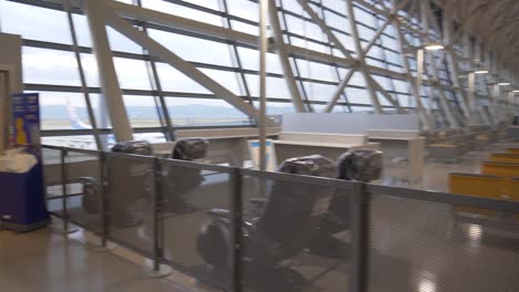 A-smooth-handheld-gimbal-shot-of-the-walkway-from-the-ANA-boarding-gate-to-the-aircraft-at-Kansai-Airport,-capturing-the-modern-airport-atmosphere