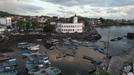 Aerial-view-showcasing-Port-Badjanan-with-empty-fishing-boats-and-the-Badjanani-Mosque-in-the-background-in-Moroni,-Comoros