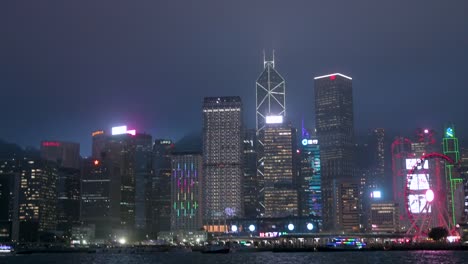 Nachtansicht-Vom-Victoria-Harbour-Mit-Der-Lebendigen-Skyline-Von-Hongkong-Und-Dem-Finanzviertel-Mit-Dem-Bank-Of-China-Tower-Und-Anderen-Wolkenkratzern