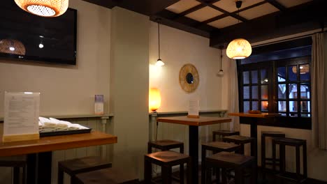 Empty-cozy-restaurant-with-modern-decor,-wooden-tables,-and-warm-lighting