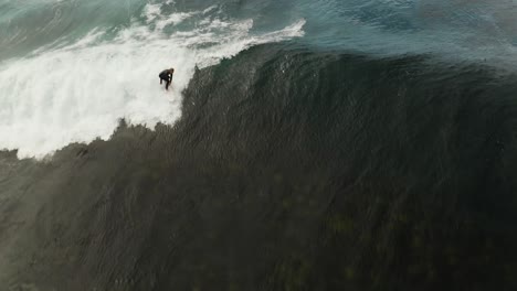 Aerial-of-surfer-riding-big-wave,-pull-down-shot-surfing-wave-on-Sydney-coast