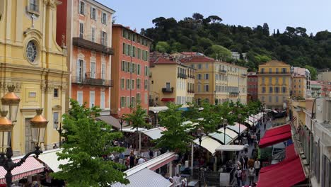 Geschäftiger-Antiquitätenmarkt-Auf-Dem-Cours-Saleya-In-Nizza,-Frankreich,-Mit-Farbenfrohen-Gebäuden-Und-Viel-Grün