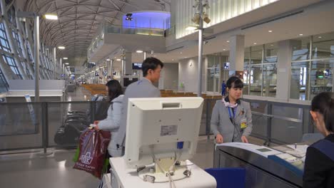 Una-Escena-Dinámica-En-La-Puerta-ANA-Del-Aeropuerto-De-Kansai-En-Osaka,-Que-Muestra-Al-Personal-De-La-Aerolínea-Ayudando-A-Los-Pasajeros-Durante-El-Embarque.