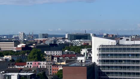 Wide-shot-of-Cityscape-with-colorful-houses-and-container-harbor-with-cranes-in-background