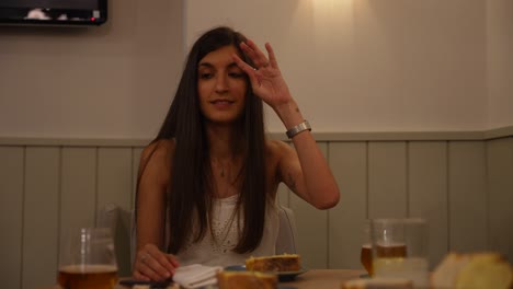 Woman-looking-at-both-sides-to-listen-and-talk-with-people-during-a-meal-in-a-restaurant