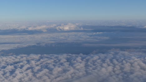 Layers-of-clouds-moving-from-left-to-right-viewed-for-overhead-out-a-aircraft-window